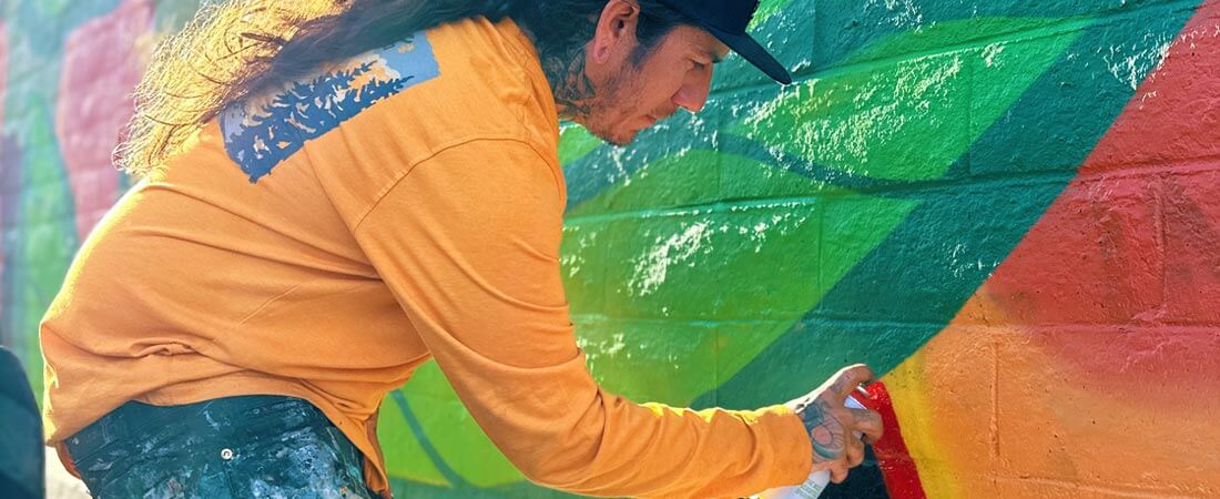 muralist Anthony Ortega painting the Pear Tree mural